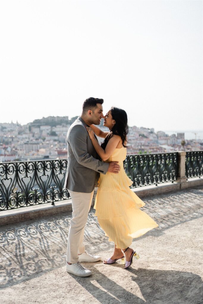 A couple in São Pedro de Alcantara viewpoint in Lisbon, early in the morning, for a love story photography session