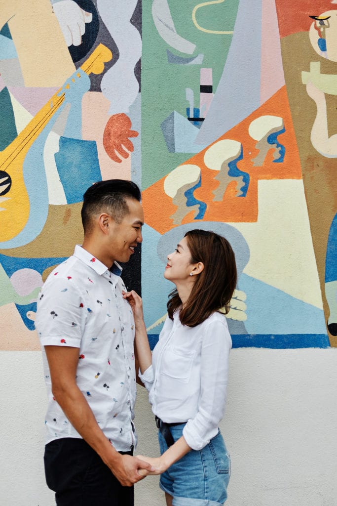 Eliza Sam and Joshua Ngo pose in front of a mural painting in Lisbon, as part of a Romantic photoshoot with Lisbon Photographers Your Story in Photos