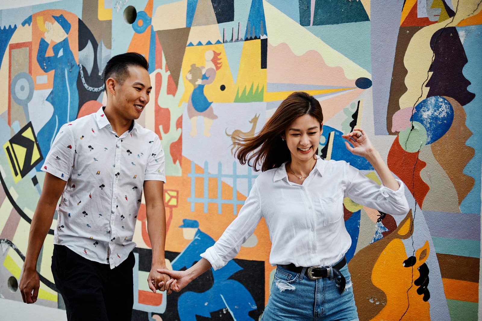 Eliza Sam and her husband walk in front of a piece of street art in the Mouraria neighbourhood in Lisbon, as part of a shoot with Lisbon photographers Your Story in Photos