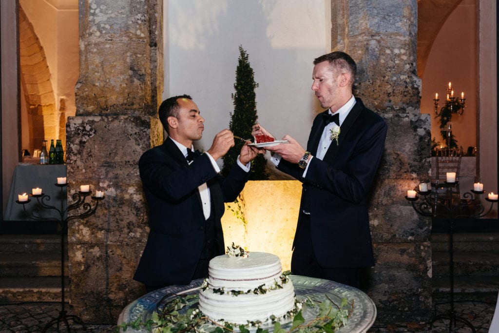 Grooms eating the wedding cake on their wedding day in Lisbon, Portugal
