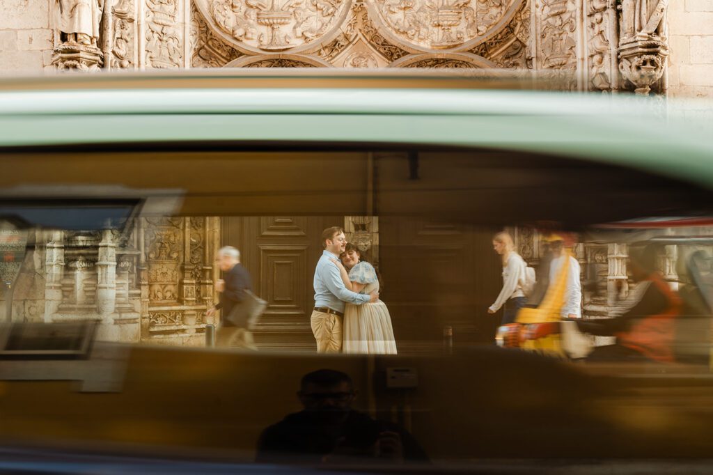couple shot through a taxi window during a love story photoshoot in Lisbon in a busy street