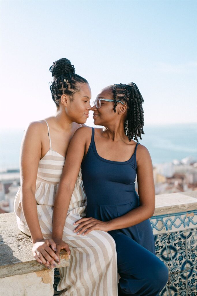 a couple nose to nose with portuguese tiles in the backdrop, at miradouro de Santa Luzia, in early morning light