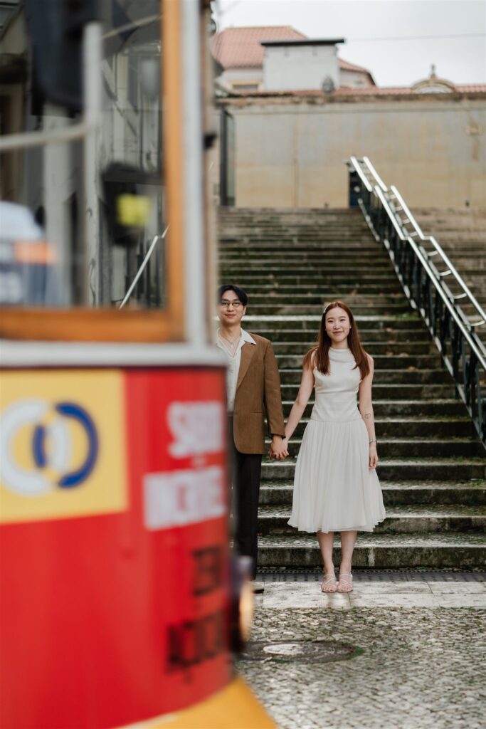 Trolley passes in front of couple in a Lisbon street