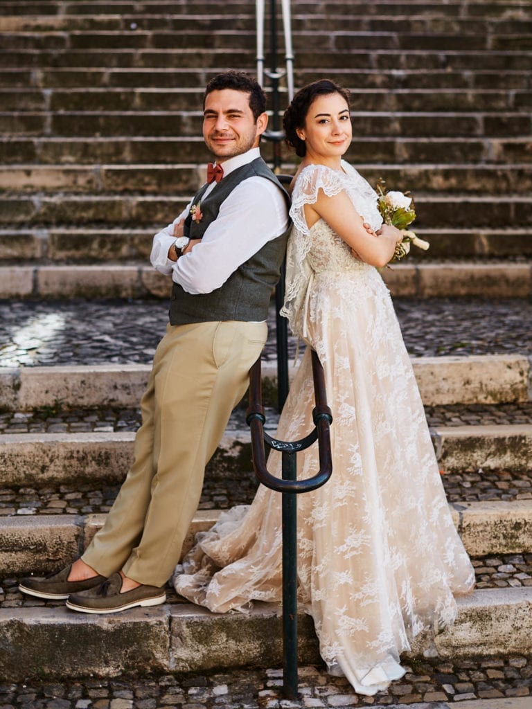 a couple poses back to back for a wedding photo, on their elopement in Lisbon