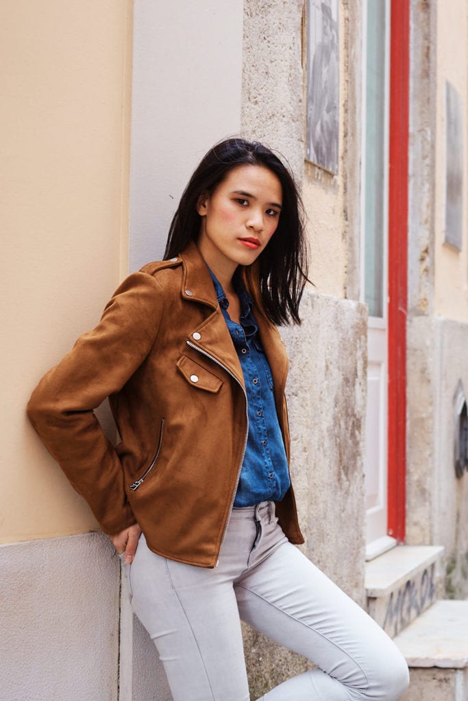 a girl leans against the wall looking at the camera posing for a photo as part of a branding session