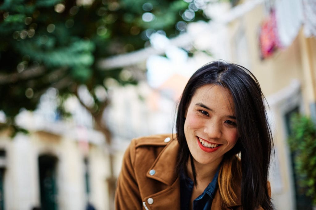 a girl smiles during her professional photo session in Lisbon