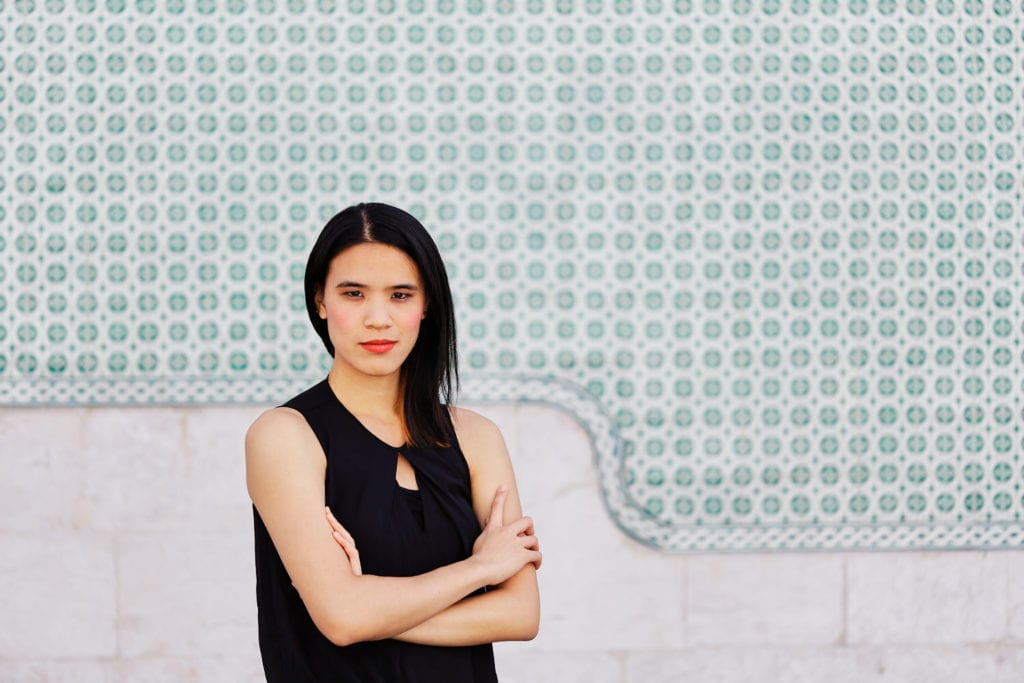 a girl in a business pose against a backdrop of painted tiles in Lisbon, Portugal | Photo by Personal branding photographer Your Story in Photos